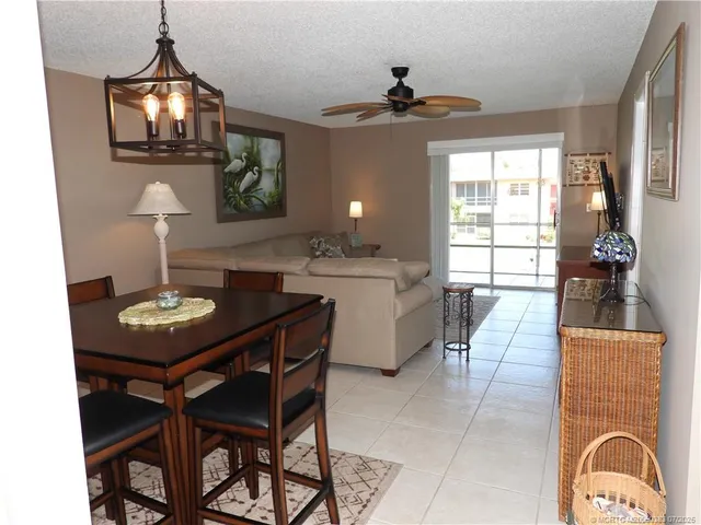 a view of swimming pool with outdoor seating and trees in the background