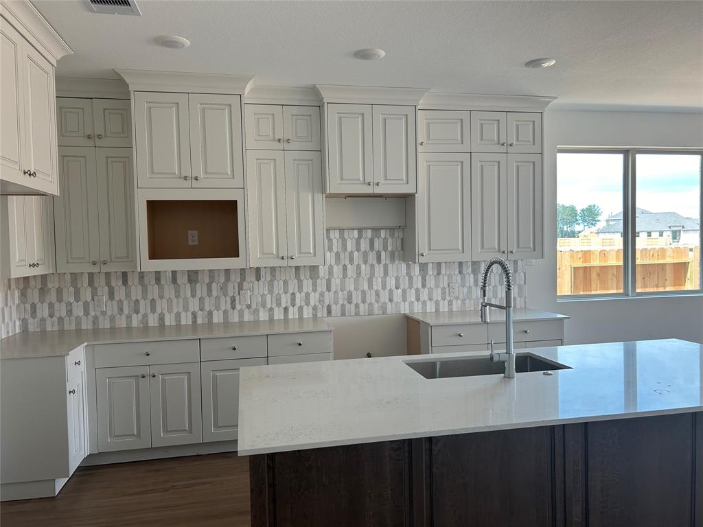 a kitchen with white cabinets a sink and dishwasher
