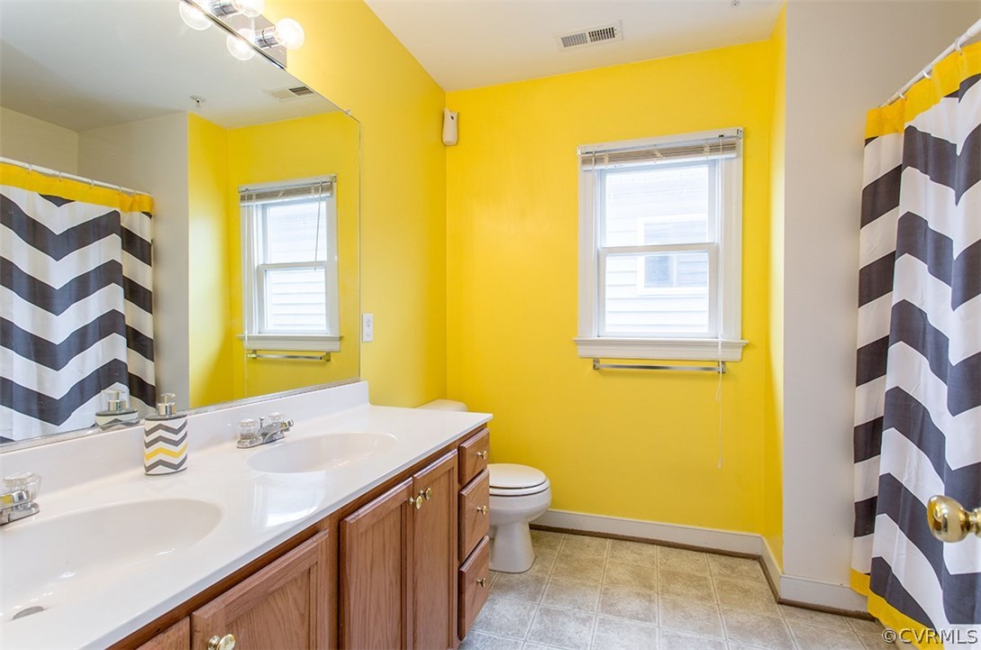 1317 Decatur Street Richmond, VA 23224 - Photo 14 of 18 a bathroom with a sink a toilet and a mirror