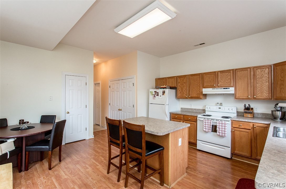 1317 Decatur Street Richmond, VA 23224 - Photo 6 of 18 a kitchen with stainless steel appliances kitchen island granite countertop a table chairs sink and cabinets