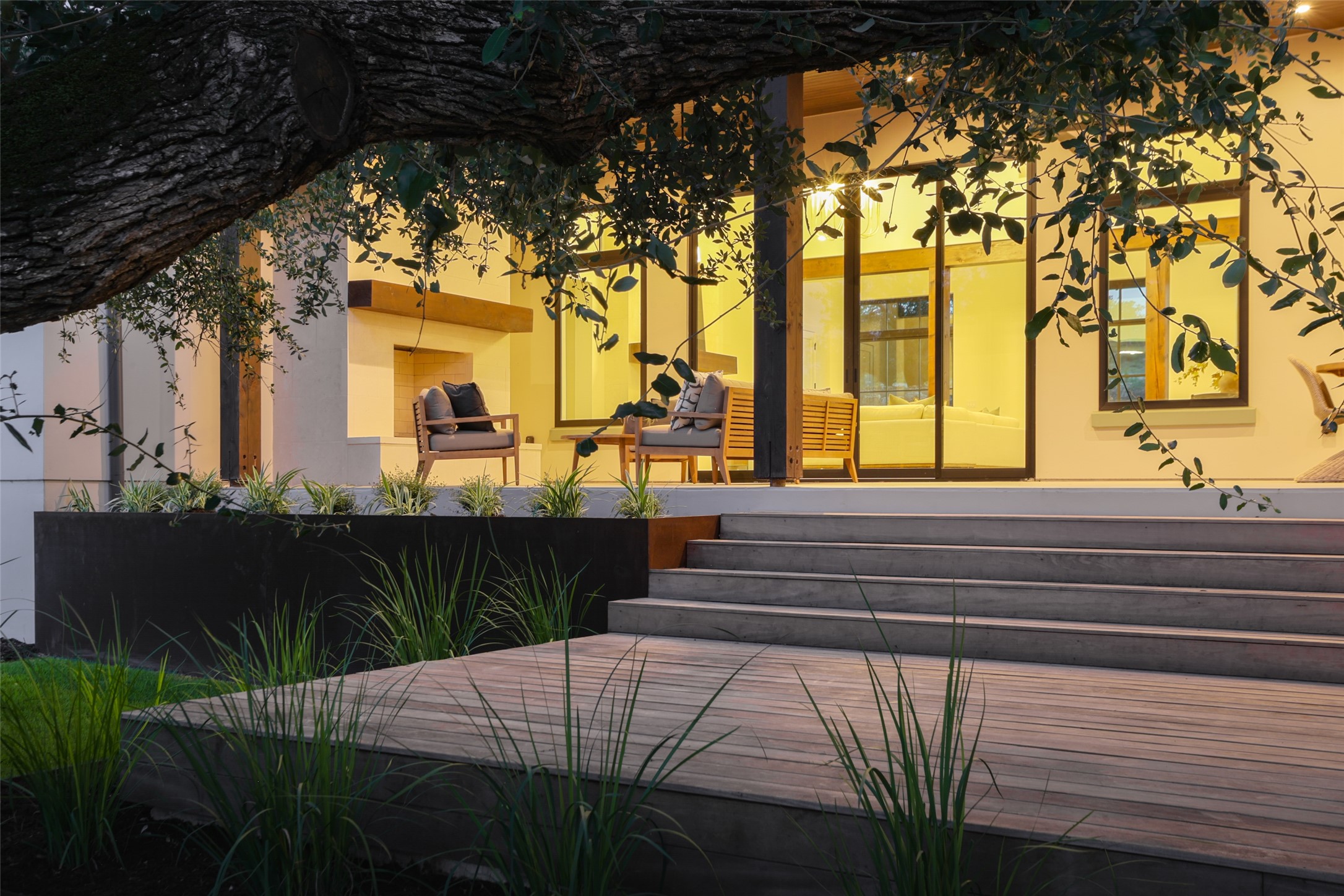 125 Broadwing Cove Austin, TX 78737 - Photo 31 of 40 Seamless indoor-outdoor flow. This expansive covered back porch serves as a true extension of the home, featuring durable Garapa decking and a wood-plank ceiling. It’s a massive, shaded space designed for lounging poolside while taking in the quiet views of the 1.06-acre greenbelt lot.