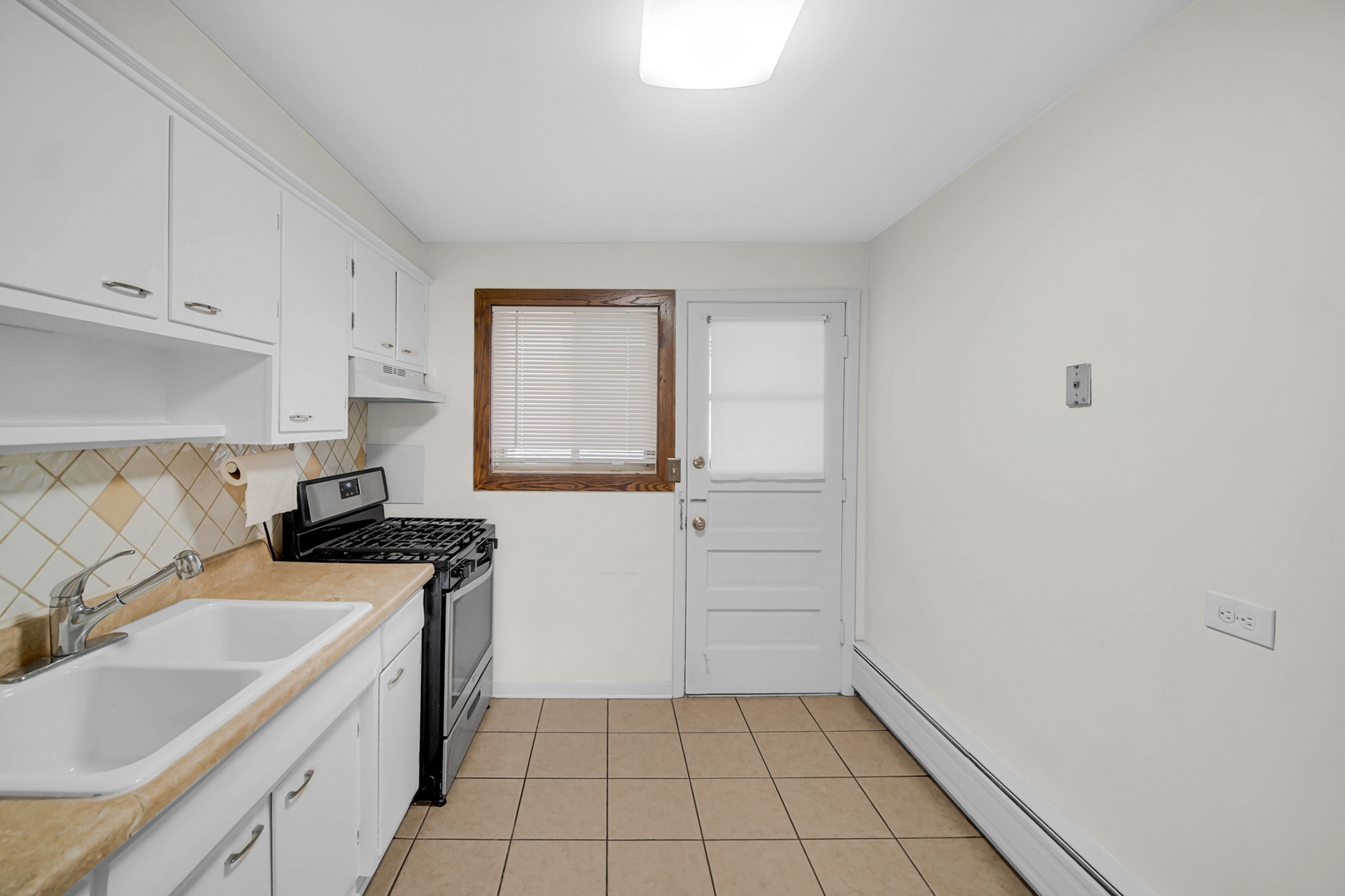 7019 North Ridge Boulevard, Unit 3B Chicago, IL 60645 - Photo 16 of 21 a kitchen with a sink stove and cabinets