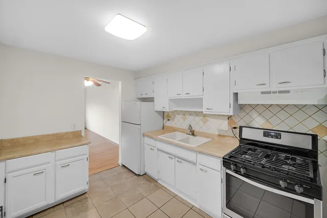 a kitchen with granite countertop a sink stove and cabinets