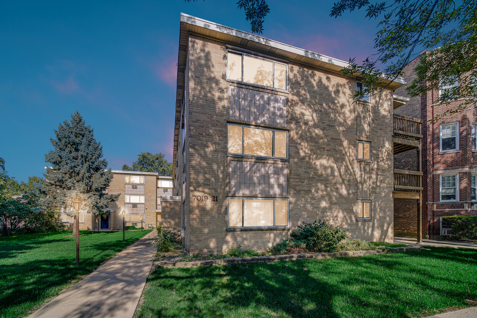 7019 North Ridge Boulevard, Unit 3B Chicago, IL 60645 - Photo 3 of 21 a large brick building with a yard in front of it