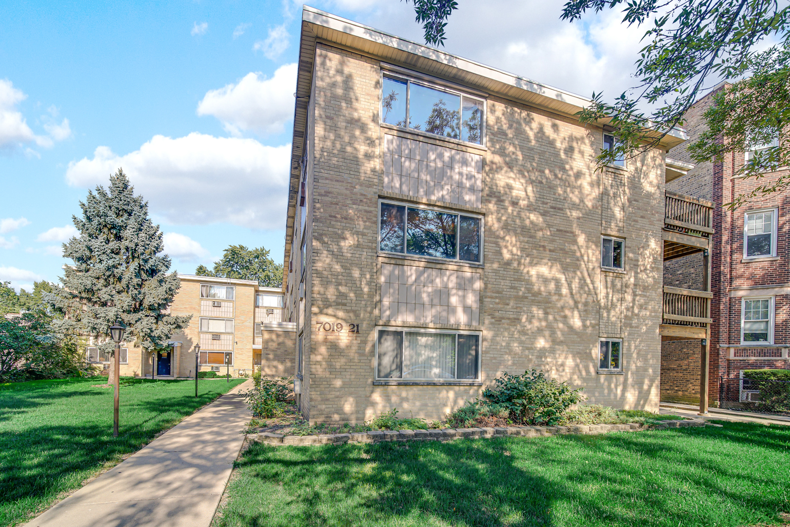 7019 North Ridge Boulevard, Unit 3B Chicago, IL 60645 - Photo 4 of 21 a view of a brick building next to a yard