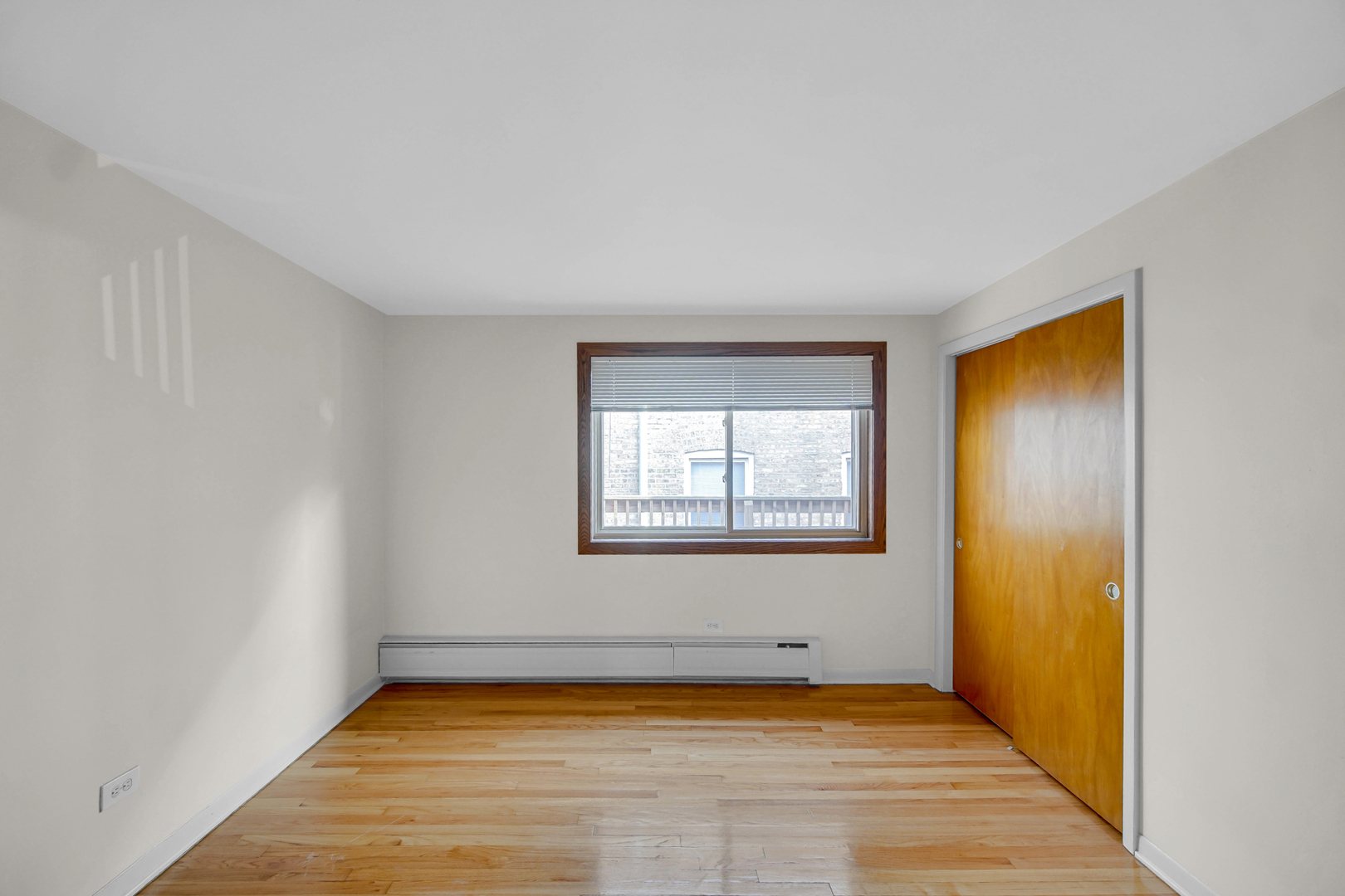 7019 North Ridge Boulevard, Unit 3B Chicago, IL 60645 - Photo 10 of 21 a view of an empty room with window and wooden floor