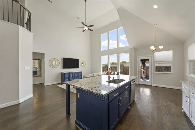 a living room with stainless steel appliances granite countertop a sink and a refrigerator