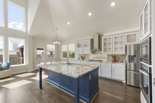a kitchen with stainless steel appliances granite countertop a sink stove and refrigerator