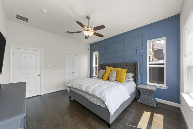 a bedroom with a bed ceiling fan and a window