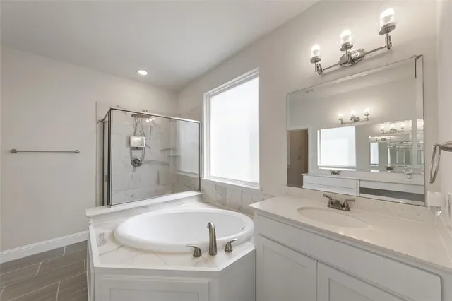 a bathroom with a sink a large mirror and a bathtub