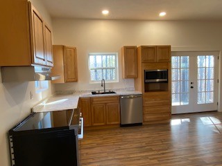 221 Howard Switch Road Hohenwald, TN 38462 - Photo 6 of 20 a kitchen with stainless steel appliances granite countertop a sink a stove counter space and wooden floor