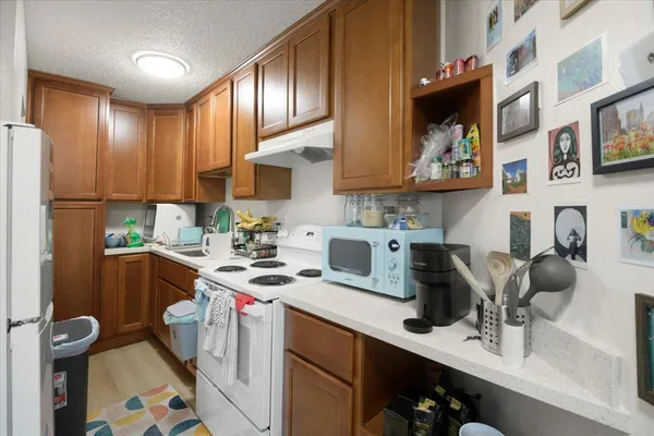 a kitchen with stainless steel appliances a sink a stove a refrigerator and cabinets