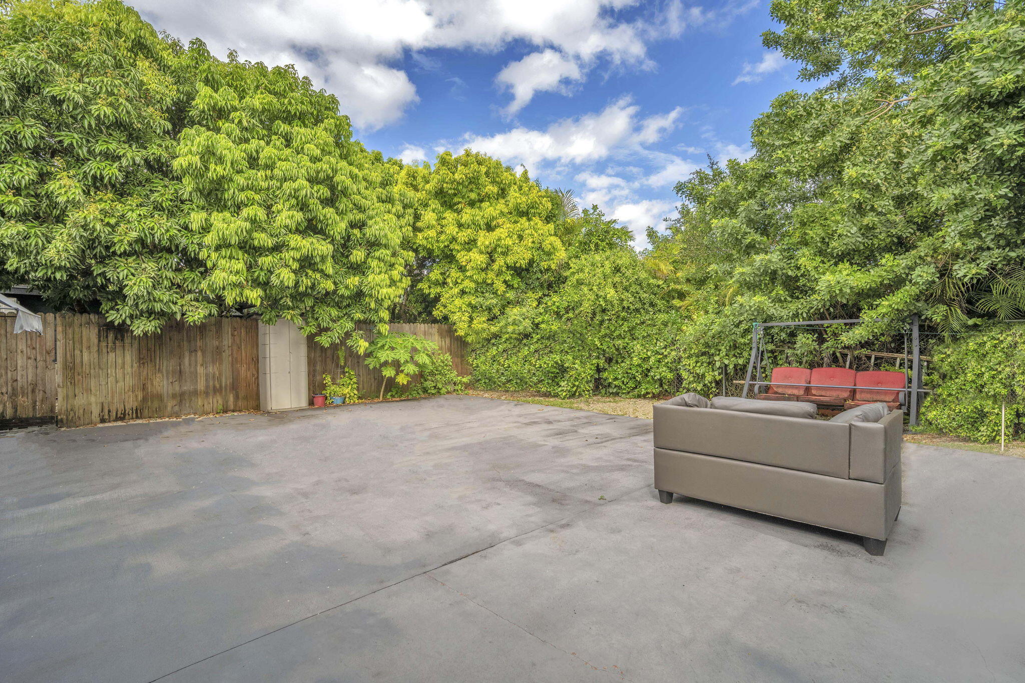 15225 Southwest 235th Street Homestead, FL 33032 - Photo 63 of 96 a backyard of a house with large trees and outdoor seating