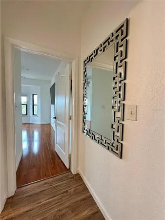 a view of a hallway with wooden floor and staircase