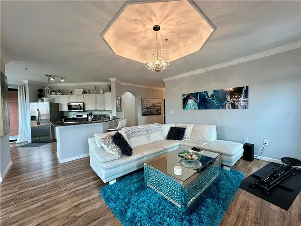 a kitchen with granite countertop kitchen island stainless steel appliances a sink and a refrigerator