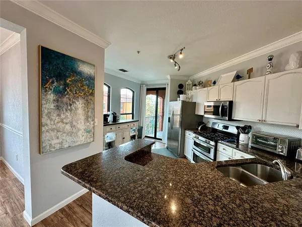 a kitchen with stainless steel appliances granite countertop a refrigerator oven stove and a refrigerator