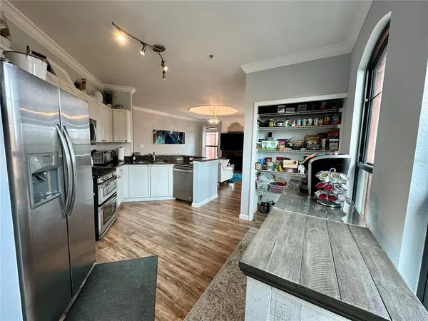 a kitchen with stainless steel appliances kitchen island granite countertop a refrigerator a sink a stove and island