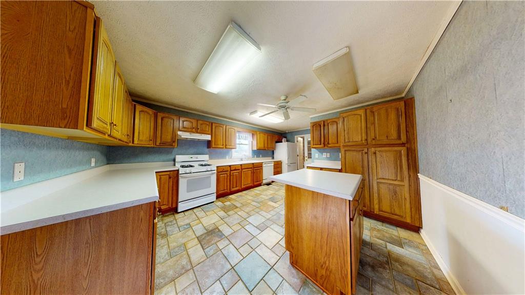 40 Lois Road Southwest Euharlee, GA 30120 - Photo 17 of 37 a kitchen with stainless steel appliances kitchen island granite countertop a stove a sink dishwasher and cabinets with wooden floor