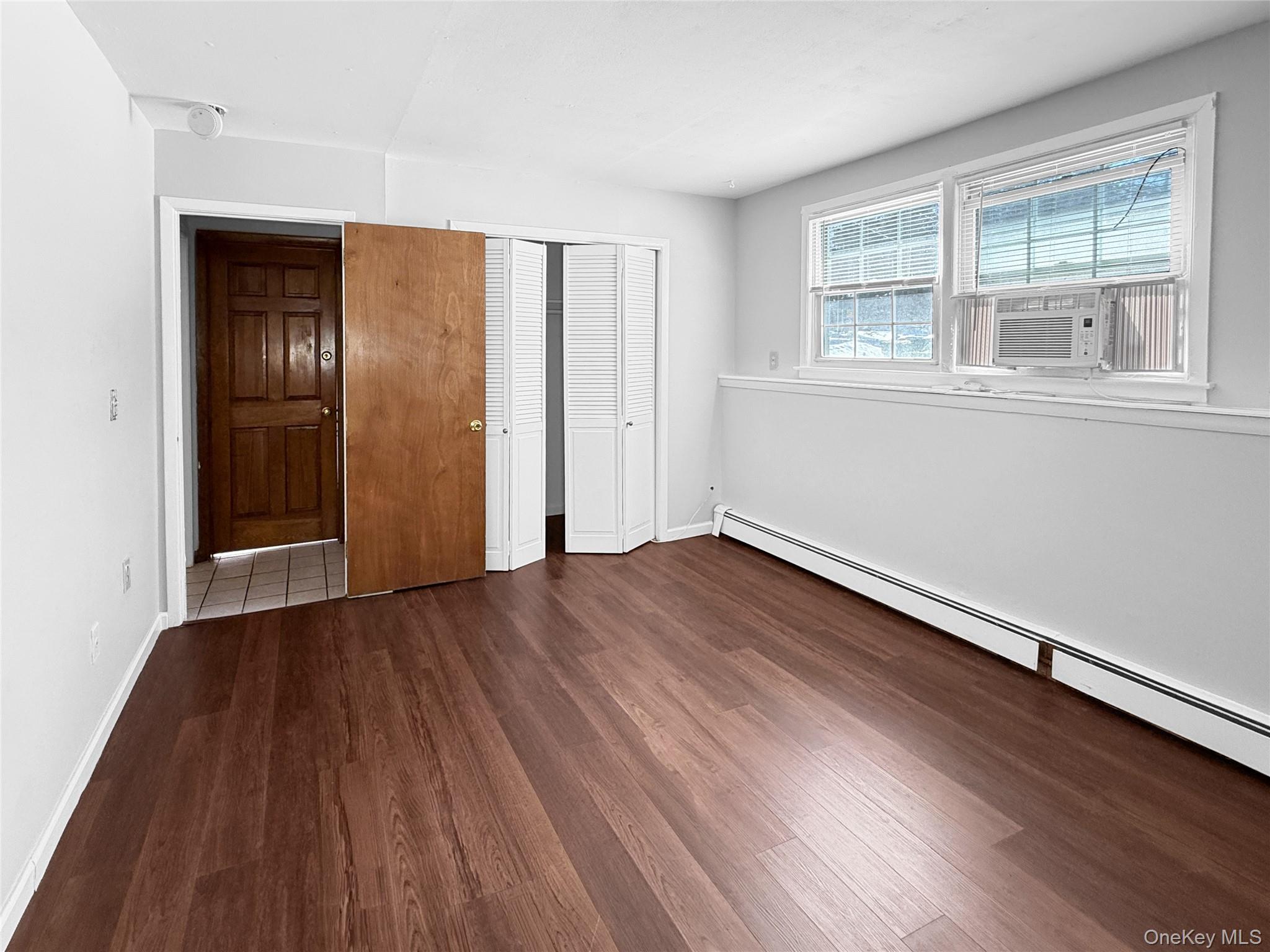 83 Kent Road, Unit LOWR Wappingers Falls, NY 12590 - Photo 10 of 11 an empty room with wooden floor and windows