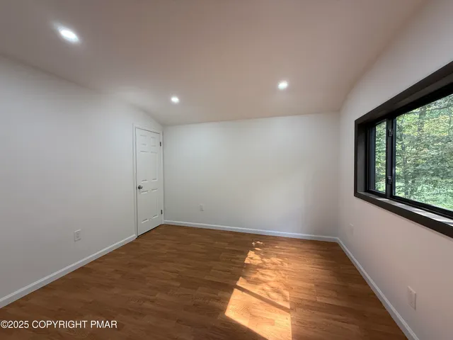 a view of room with window and wooden floor