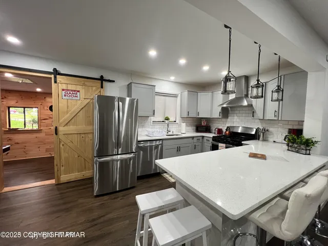 a kitchen with stainless steel appliances a refrigerator and a stove top oven