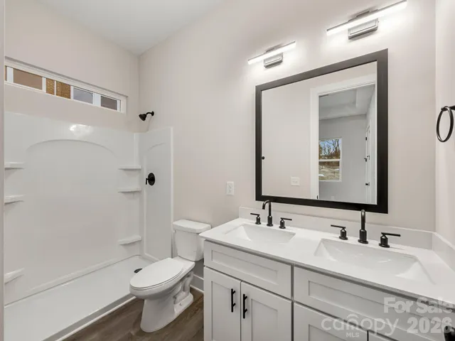 a bathroom with a sink a toilet and shower