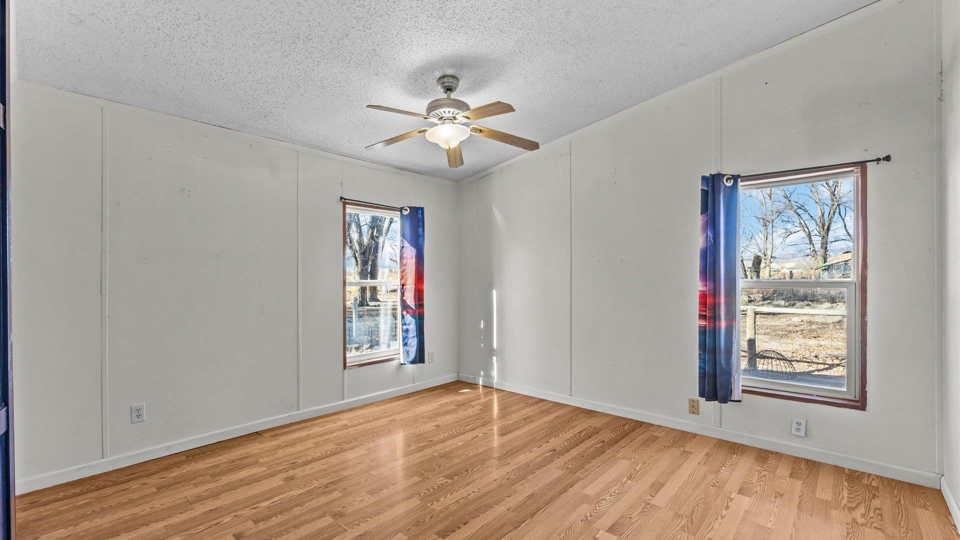 777 1550th Road Delta, CO 81416 - Photo 14 of 32 a view of an empty room with window and wooden floor