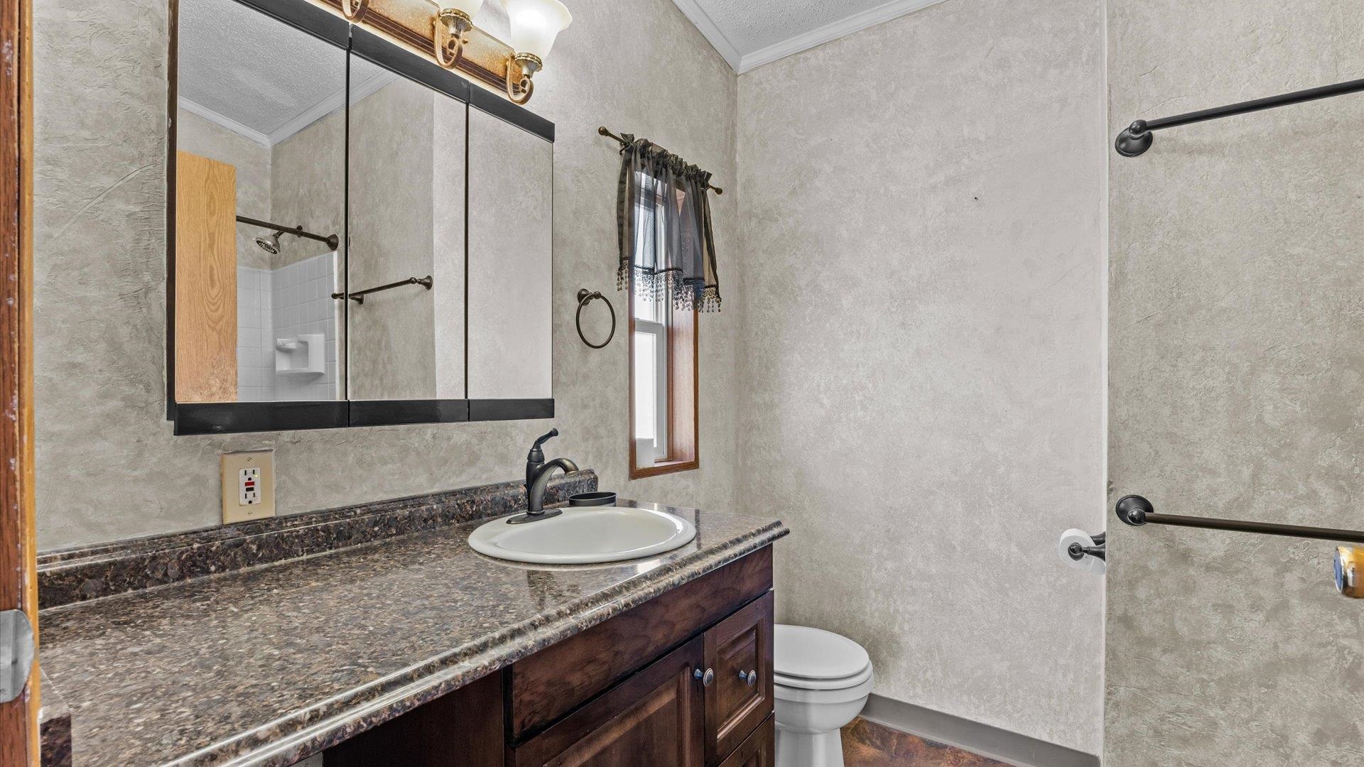 777 1550th Road Delta, CO 81416 - Photo 16 of 32 a bathroom with a granite countertop sink toilet and shower
