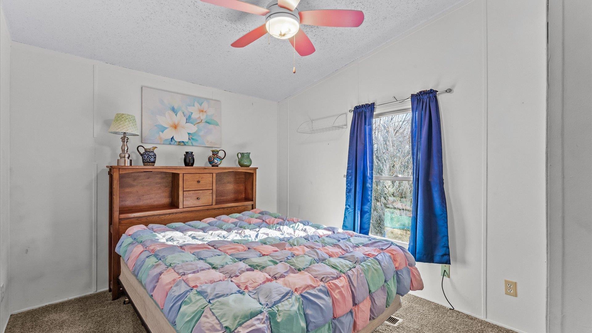 777 1550th Road Delta, CO 81416 - Photo 18 of 32 a bedroom with a bed and a chandelier