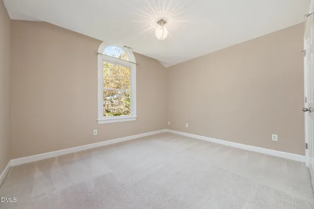 a bathroom with a toilet a sink a mirror and a window