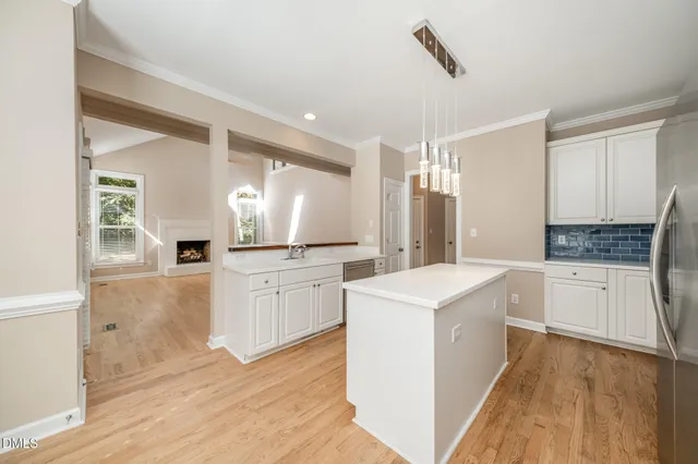 a large kitchen with a lot of counter space and wooden floor