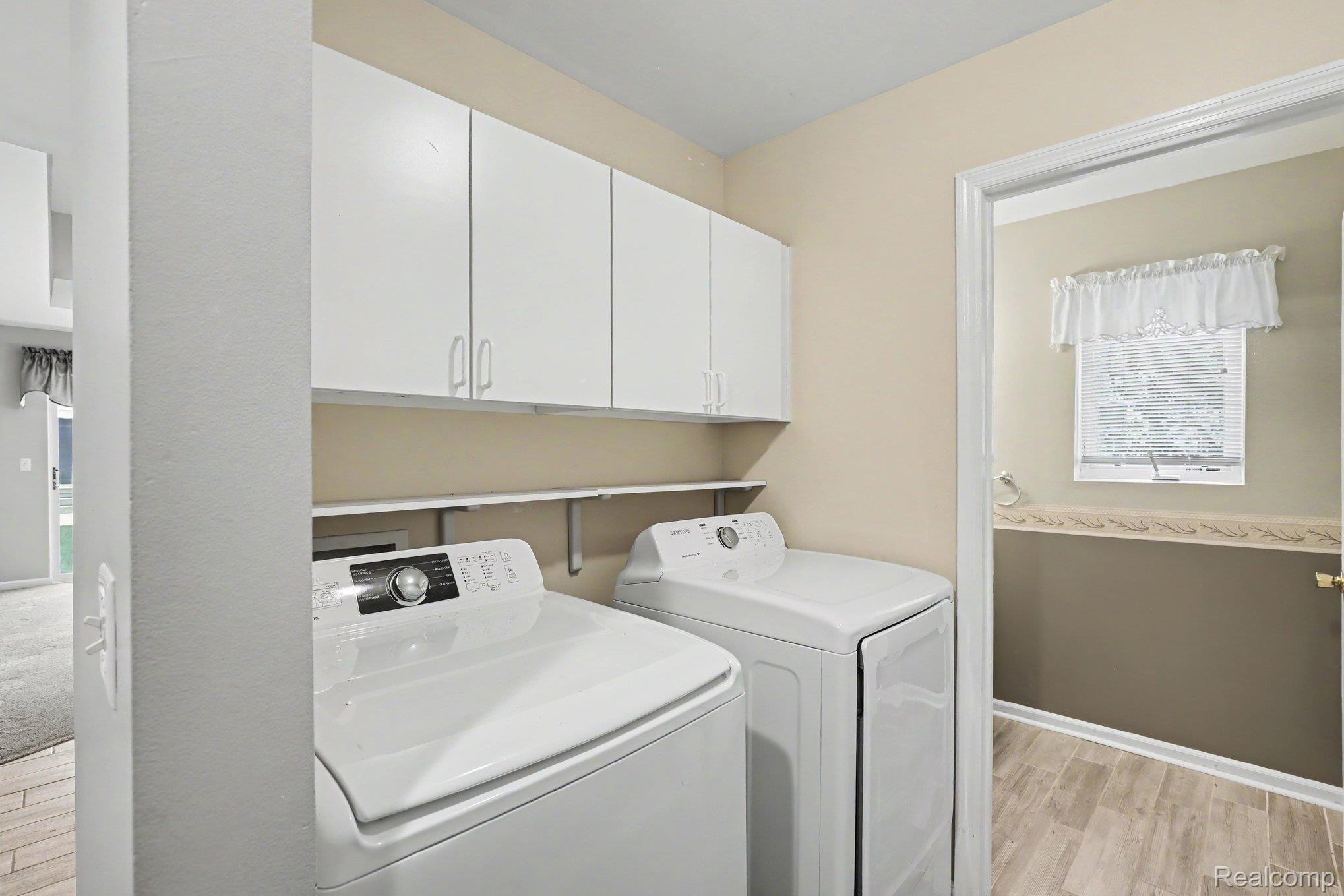 34917 Chickadee Ridge Richmond, MI 48062 - Photo 26 of 32 Integrated laundry area featuring wood-finish flooring and upper cabinetry