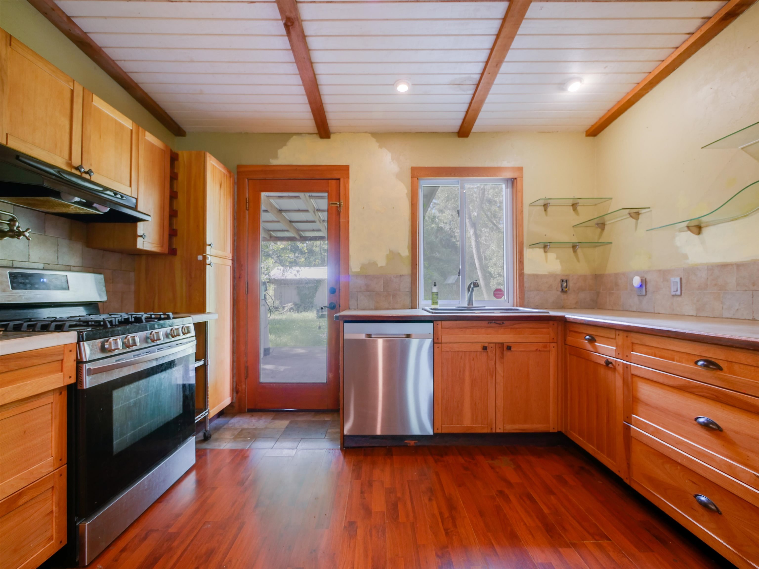 262 Spring Street St. Augustine, FL 32084 - Photo 7 of 25 a kitchen with granite countertop wooden floors and stainless steel appliances