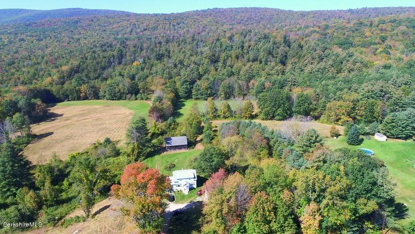 457 Horrigan Road Clarksburg, MA 01247 - Photo 1 of 32 an aerial view of green landscape with trees houses and mountain view