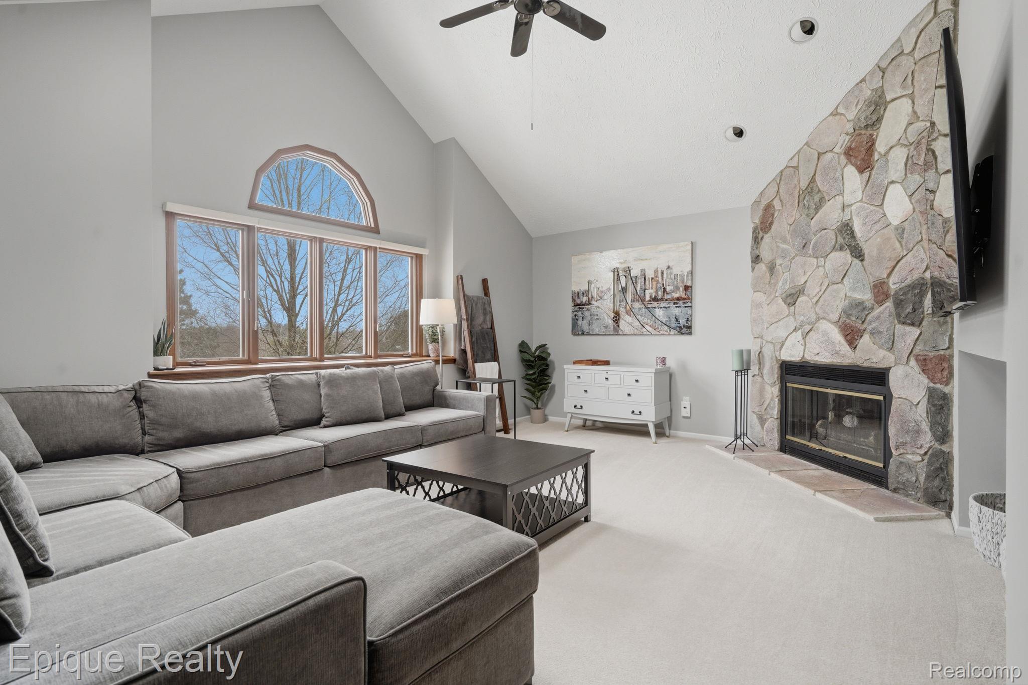 6607 Ridgeview Drive Clarkston, MI 48346 - Photo 8 of 25 Carpeted living area with a ceiling fan, a fireplace, and vaulted ceiling