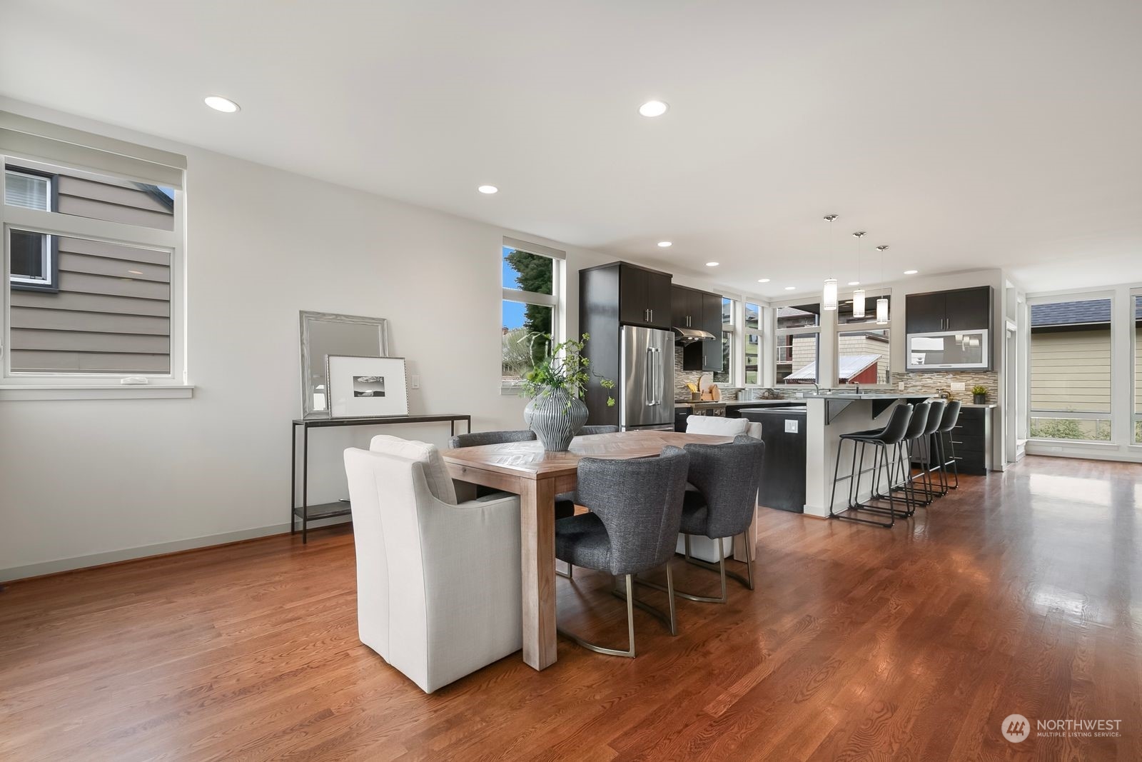 2832 Northwest 65th Street Seattle, WA 98117 - Photo 11 of 38 a dining room with stainless steel appliances wooden floors a table and chairs