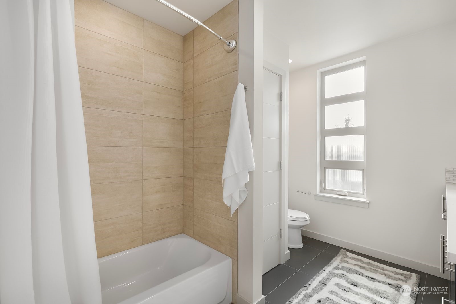 2832 Northwest 65th Street Seattle, WA 98117 - Photo 30 of 38 a bathroom with a bathtub a window and a shower