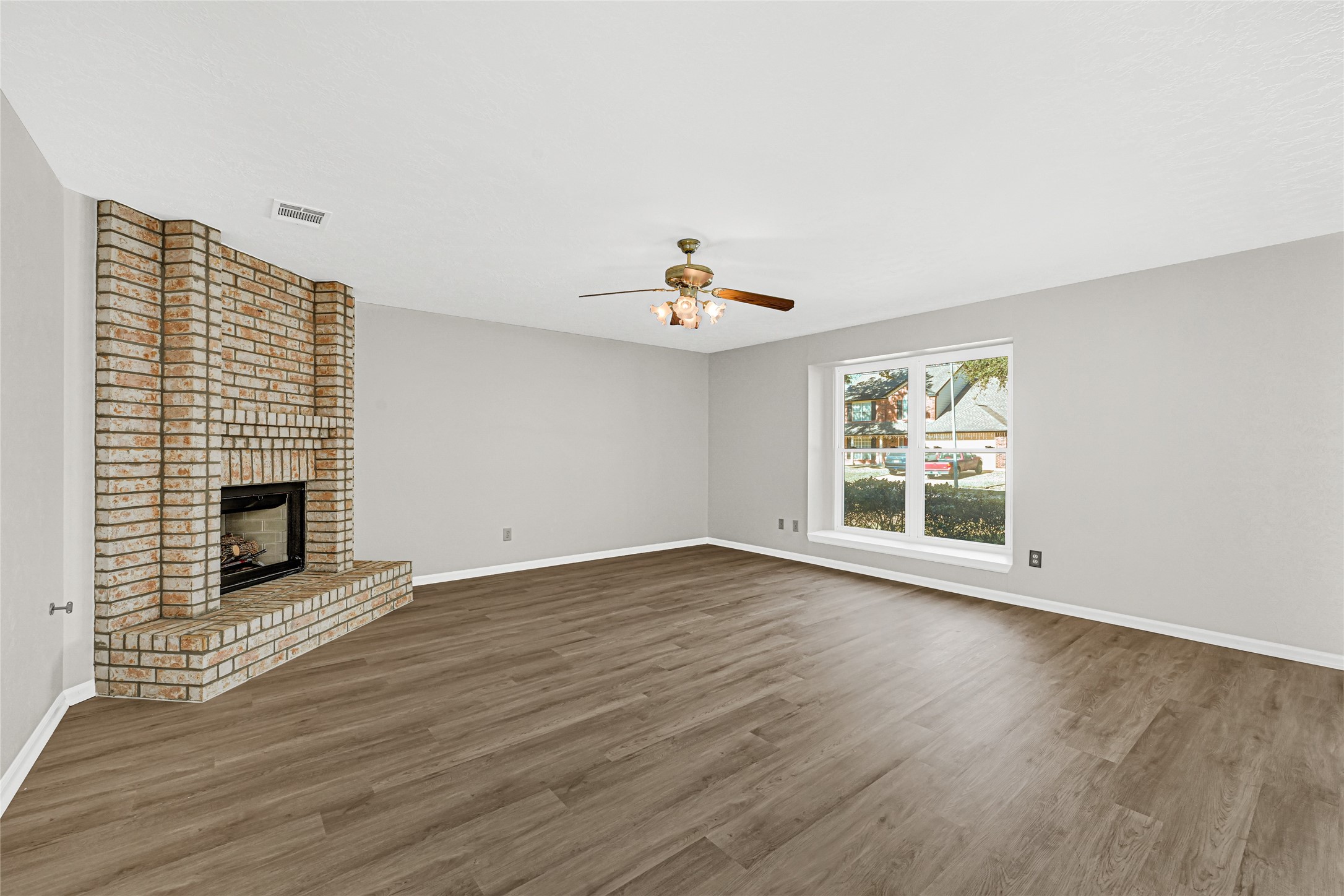 10210 Crooks Way Court Houston, TX 77065 - Photo 12 of 50 an empty room with wooden floor a fireplace and windows