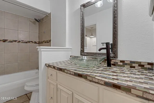 a bathroom with a granite countertop sink and a mirror