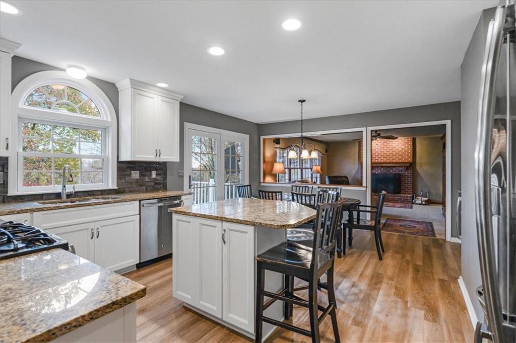 Undisclosed Address Gibsonia, PA 15044 - Photo 12 of 35 a kitchen with stainless steel appliances granite countertop a stove top oven a sink a dining table and chairs with wooden floor
