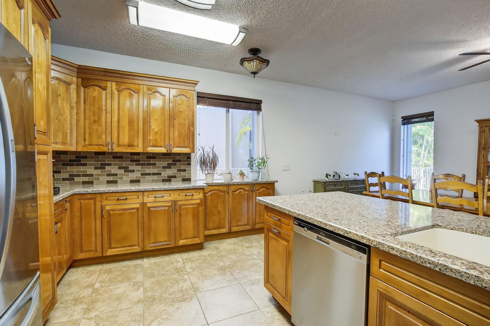 19427 Southwest 65th Street Fort Lauderdale, FL 33332 - Photo 11 of 56 a kitchen with stainless steel appliances granite countertop a sink stove and cabinets