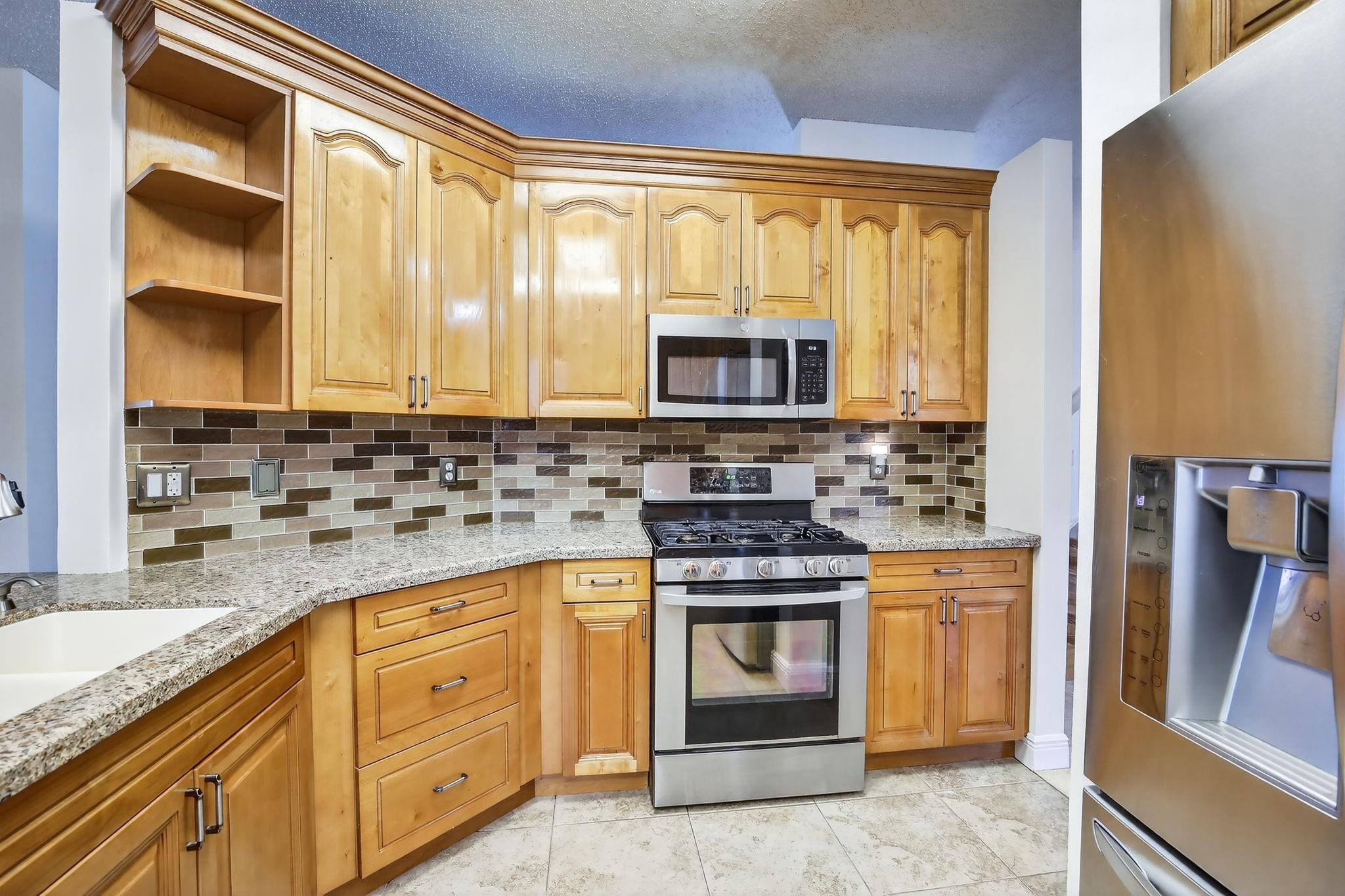 19427 Southwest 65th Street Fort Lauderdale, FL 33332 - Photo 13 of 56 a kitchen with stainless steel appliances granite countertop a stove a sink and a microwave