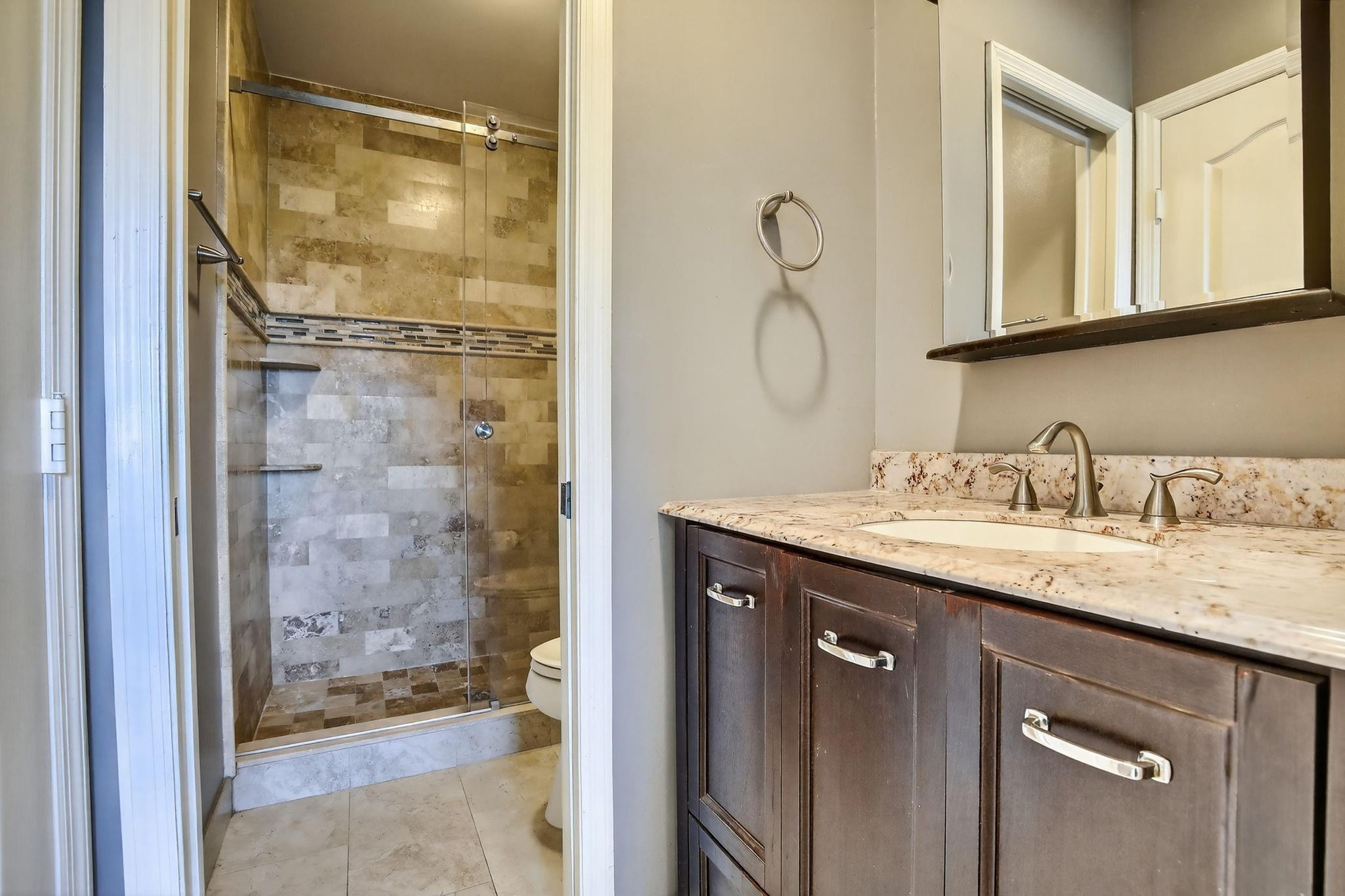 19427 Southwest 65th Street Fort Lauderdale, FL 33332 - Photo 35 of 56 a bathroom with a granite countertop sink a mirror and a shower