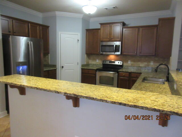 4434 Mirada Way Crestview, FL 32539 - Photo 8 of 21 a kitchen with stainless steel appliances granite countertop wooden cabinets and granite counter tops