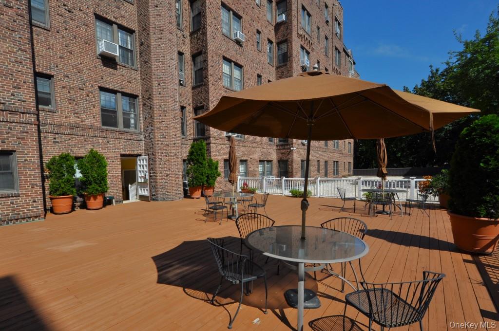 253 Garth Road, Unit 1T Scarsdale, NY 10583 - Photo 31 of 45 a view of a patio with a table and chairs under an umbrella