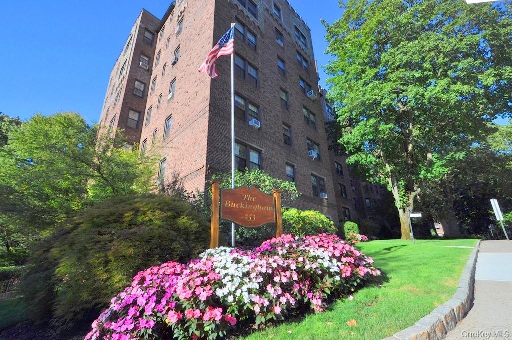 253 Garth Road, Unit 1T Scarsdale, NY 10583 - Photo 4 of 45 a view of a large building with a flower garden