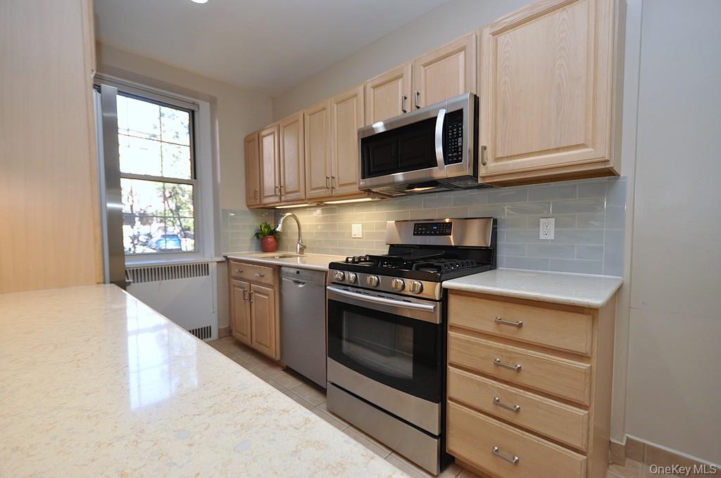253 Garth Road, Unit 1T Scarsdale, NY 10583 - Photo 8 of 45 a kitchen with stainless steel appliances granite countertop a stove microwave and sink