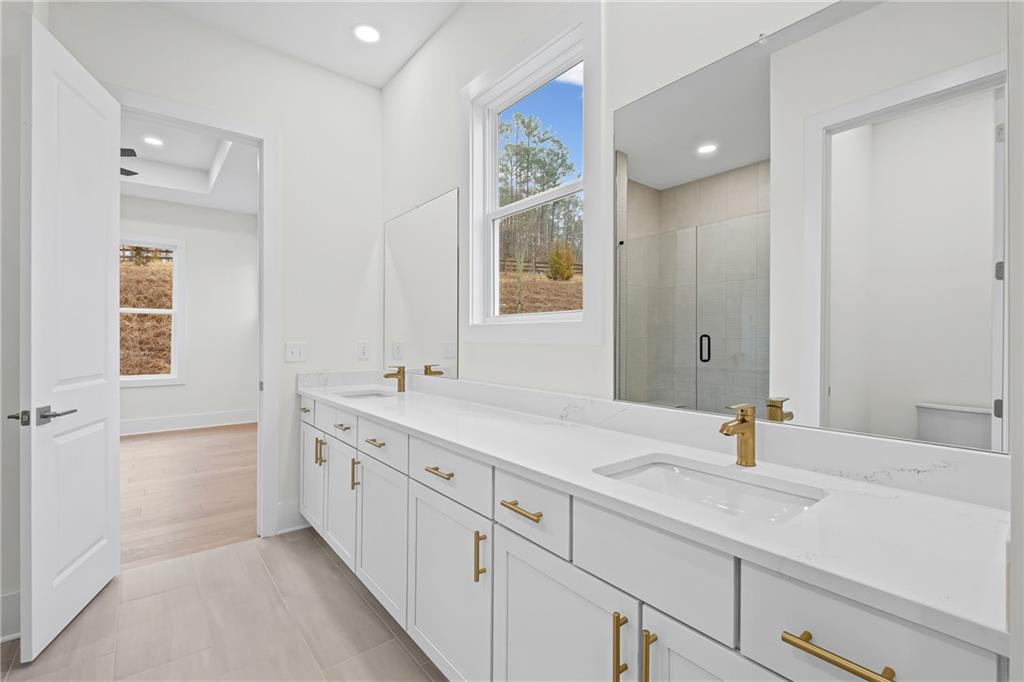 178 Mooney Road Woodstock, GA 30188 - Photo 19 of 42 a bathroom with a sink double vanity granite tub shower and a mirror