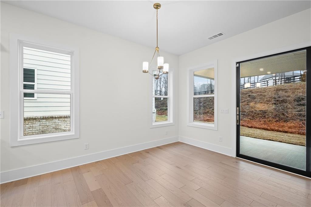 178 Mooney Road Woodstock, GA 30188 - Photo 8 of 42 an empty room with wooden floor and windows
