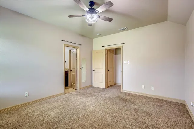 a view of an empty room and a ceiling fan